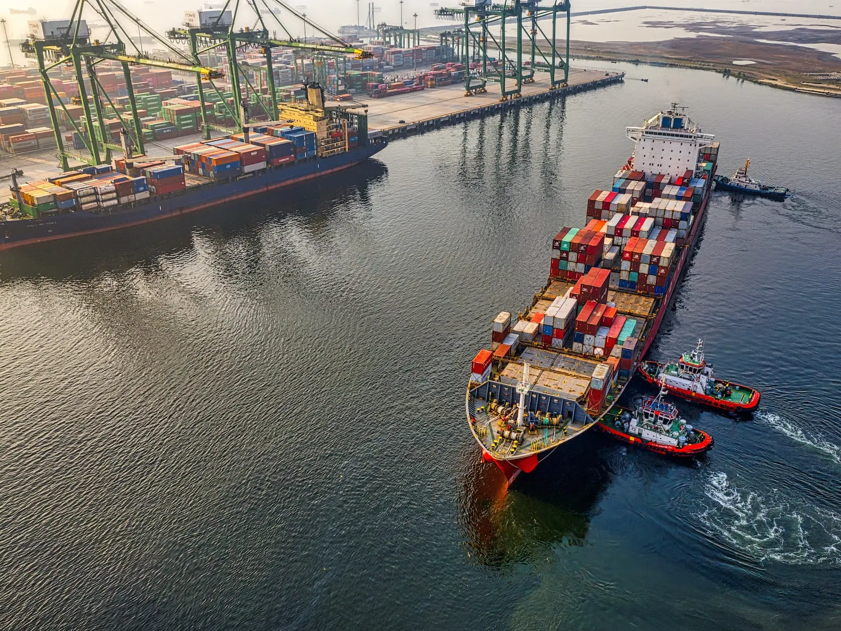 red and blue cargo ship on body of water during daytime